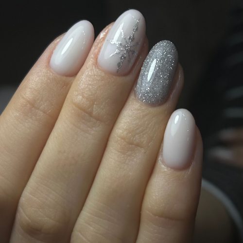 Unghii milky white cu sclipici argintiu pe degetul inelar si fulg de zapada decorativ, design festiv elegant